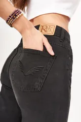 Jean mom de tiro alto color negro, con corte ajustado en la parte inferior y diseño contemporáneo.
