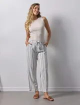 Pantalón de lino a rayas verticales grises y blancas, con pretina elastizada, lazo de ajuste y bolsillos delanteros y traseros.