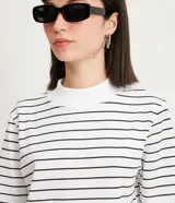 Remera de media malla blanca con rayas horizontales negras, cuello alto y mangas cortas.