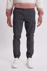 Pantalón cargo estilo jogger color gris oscuro, con bolsillos laterales y tobillos ajustados con elástico.