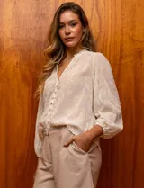 Blusa color blanco de gasa bordada, marca Figueroa & Flower. Tiene cuello a la base con detalle plisado y escote en V. Cuenta con apertura central con botones de nacar y mangas largas con terminación fruncida.