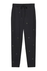 Pantalón de jogging negro con estrellas doradas estampadas, cintura elástica con cordón ajustable y puños elásticos.