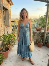 Vestido largo maxi de tirantes halter, escote en V profundo y cintura fruncida. Presenta un estampado paisley en tonos azules y turquesas.
