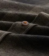 Camisa regular de algodón con estampado de cuadros en tonos verde y negro, cuello camisero, manga larga, abotonada al frente y bolsillo en el pecho.