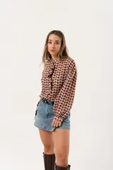 Minifalda de jean azul claro con corte evasé, detalle de short interno y cinturón negro con argollas metálicas.