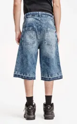 Bermuda de denim larga con calce oversize, desgaste y ruedo desflecado.