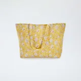 Bolso shopper acolchado amarillo con estampado floral en tonos beige.