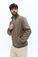 Campera de algodón con cierre frontal, cuello alto en color verde oliva y cuerpo texturado con patrón de espiga en tono marrón topo. Las mangas son lisas y del mismo tono que el cuerpo. Presenta un pequeño logo bordado en el pecho.