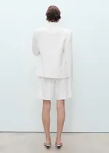 Short de algodón blanco, estilo vaquero, con tiro alto, trabillas, cierre de cremallera y botón, cinco bolsillos y corte recto.