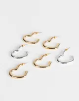 Set de tres pares de aros tipo argolla con forma de corazón, uno plateado y dos dorados.