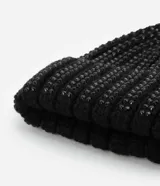 Gorro de punto negro con brillos y pompón en la parte superior.