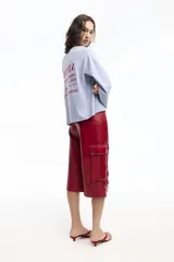 Remera blanca de manga larga con cuello redondo y pequeño logo estampado en el pecho y en la manga.