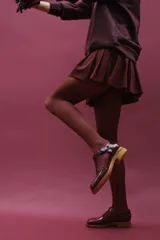 Zapato guillermina de cuero vacuno charol color negro, con suela de goma color marrón.