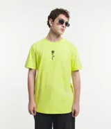 Remera color amarillo flúor de corte recto, con cuello redondo y manga corta. Presenta un bordado de una rosa negra en el lado izquierdo del pecho.