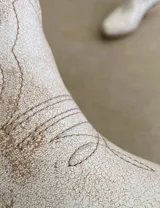 Botas cortas negras de cuero con bordados blancos estilo cowboy.