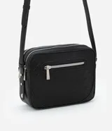 Bolso bandolera pequeño color marrón con textura geométrica en relieve. Tiene correa larga regulable, cierre de cremallera y separadores internos.