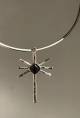 Gargantilla con cordones de gamuza marrón y dije de sol dorado con piedra de ágata en el centro.
