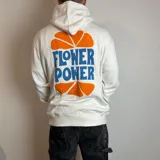 Canguro blanco con capucha, corte regular y estampado en la espalda con la frase "Flower Power" y una naranja cortada a la mitad.