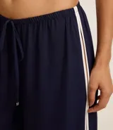 Pantalón de playa confeccionado en viscolino azul marino con lazo en la cintura y bies contrastante blanco en los laterales.