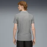 Polo gris de hombre con detalles en negro y amarillo. Logo de Puma bordado en amarillo en el pecho y escudo del Club Atlético Peñarol bordado en el pecho.