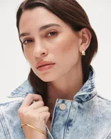 Aros pequeños de bronce con forma irregular y acabado liso, estilo huggie o argolla gruesa.