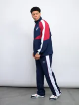 Pantalón de nylon azul marino con laterales en contraste blanco y rojo, logo de Umbro y escudo del Club Nacional de Football.