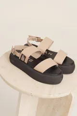 Sandalias con plataforma color beige, con dos tiras anchas sobre el empeine y tira con hebilla alrededor del tobillo.