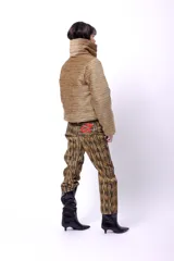 Campera corta con estampado abstracto en tonos marrones y beige, cuello alto, cierre frontal con botones a presión, bolsillos delanteros y bordado negro con las iniciales CP. Forro interior y relleno liviano de guata.