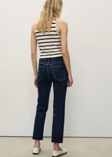 Jeans de tiro alto color azul oscuro, corte recto, con cierre de cremallera y botón, cinco bolsillos y diseño crop.
