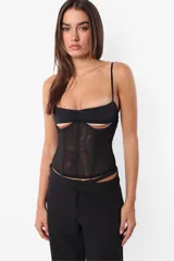 Corset blanco de microtul en el cuerpo y microfibra en el busto, con sustracción debajo del busto y frunce. Tiene ganchos lenceros en la espalda, ballenas con refuerzo en los recortes y terminaciones con elástico.