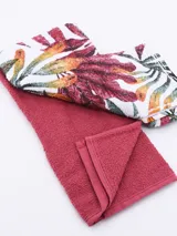 Set de dos repasadores de cocina, uno liso color rosado y otro estampado con hojas de colores.