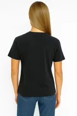Remera negra de algodón con cuello redondo y estampado frontal de un motel en el desierto.
