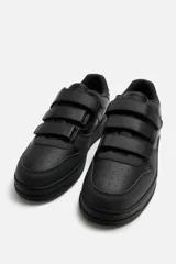 Zapatillas deportivas negras con triple cierre adherente, combinación de piezas en el corte y suela con ligero volumen. Diseño de inspiración retro.