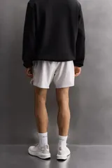 Shorts deportivos color verde oliva confeccionados en tejido técnico ligero y elástico. Cuenta con forro interior, cintura elástica ajustable con cordón, bolsillos laterales, bolsillo de seguridad en espalda con cierre de cremallera, bajo con aberturas laterales y logo estampado en la pierna.