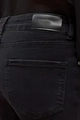 Jean negro de tiro medio, corte bootcut, con tachas metálicas plateadas decorando los laterales de las piernas y el ruedo.