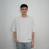 Remera blanca de algodón con corte oversize y estampado con la palabra 'nenefa' en cursiva negra en la espalda.