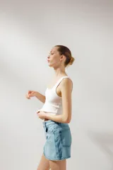 Minifalda de jean celeste con tiro medio, trabillas, cinco bolsillos y cierre frontal con cremallera y botón metálico.