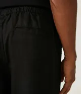 Pantalón cargo negro confeccionado en liocel con cintura elástica, cordón de ajuste y bolsillos laterales.