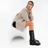 Bota alta de cuero vacuno color negro, con suela de goma artesanal, cierre interno YKK, hebillas ajustables y estribo desmontable.