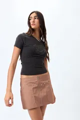 Remera color beige con cuello redondo y mangas cortas. Presenta un estampado con relieve de un corazón con un caballo en su interior y la frase "wild hearts can't be broken".