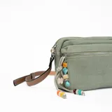 Bandolera verde de tela con correa marrón regulable y charms colgantes de cuentas de colores.