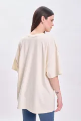 Remera manga corta oversize color crudo con estampa de sol y texto 'Le Soleil' en naranja y celeste.