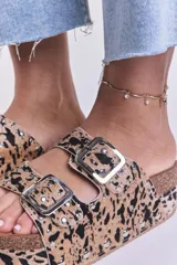 Sandalias con plataforma de corcho, con estampado animal print en tonos beige y negro, y hebillas metálicas plateadas.