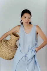 Vestido midi gris oscuro de lino, corte recto y sin mangas. Tiene bolsillos laterales y cuello redondo.