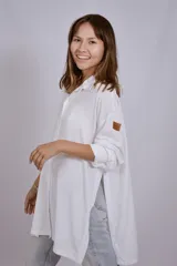 Camisa negra de corte amplio, con mangas largas y puños abotonados.