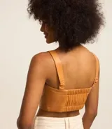 Blusa corta color ocre de material sintético con tirantes medianos con elástico y lastex en la espalda.