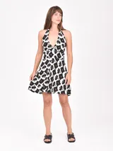 Monoprenda corta negra con estampado animal print en tonos blanco y marrón. Diseño con escote halter y espalda descubierta.