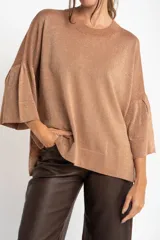 Sweater color cobre brillante, de tejido de punto con lurex, corte oversize, cuello redondo y mangas 3/4 con volados.