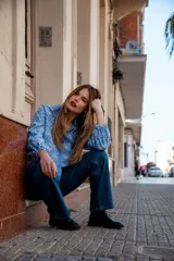 Camisa celeste con estampado de flores blancas, corte clásico, cuello camisero y mangas largas abullonadas.