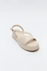 Sandalia marrón con plataforma, tiras cruzadas y pulsera ajustable.